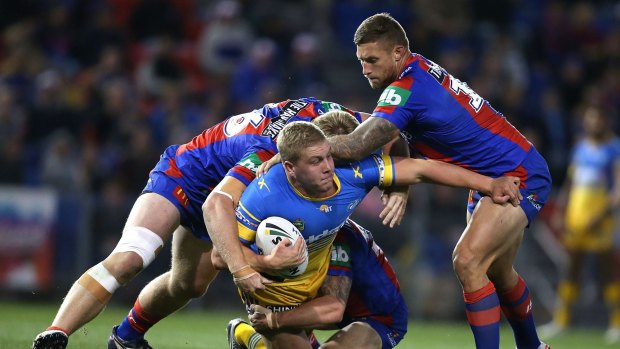 Daniel Alvaro of the Eels is taken down by Knights defenders at Hunter Stadium on Monday night. 