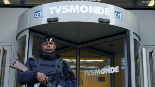 Target of Islamist hackers ... A French police officer stands guard in front of the main entrance of French television network TV5Monde headquarters in Paris on Thursday.