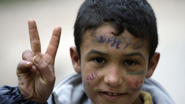 A young Syrian refugee who fled the violence in Homs with his family flashes a V for 'victory'.