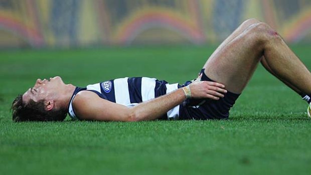 Andrew Mackie lies on the ground dejected after Geelong was defeated by the Sydney Swans.