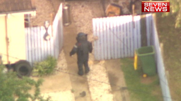 A member of the bomb squad approaches the property at the house on Dampier Street, Leichhardt, where earlier several teenagers were injured in an explosion.