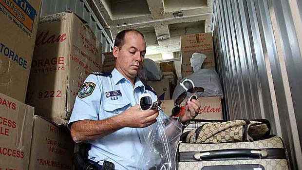 Sergeant Greg Cooper with counterfeit goods seized in raids in Sydney.