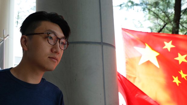 Hong Kong localist leader Edward Leung  walks past a Chinese national flag outside a court after he was charged with rioting on August 5.