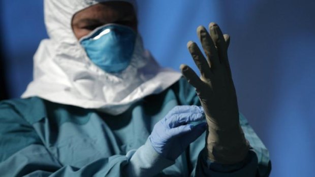 Safety first: A nurse demonstrates putting on protective clothing before dealing with an Ebola patient.