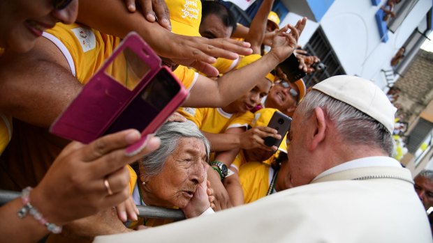 Pope Francis greets a woman after blessing her as he toured around the Plaza de Armas, in Trujillo, Peru on Saturday.