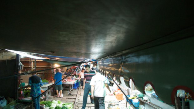 Track trade ... the market's low-hung makeshift roof - a combination that includes tarpaulins and bedspreads - which is routinely hauled in.