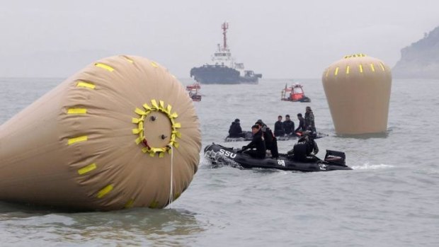 South Korean Navy rescue teams work near the buoys installed to mark the position of the sunken ferry.