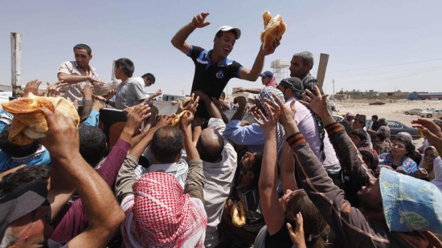 Caught in the crush: Syrian refugees gather for food aid after crossing into Iraq.