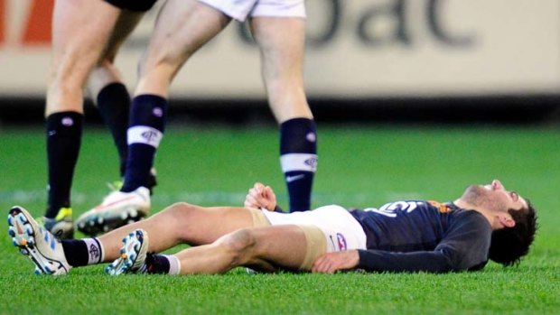 Carlton's Kade Simpson down after colliding with Collingwood's Sharrod Wellingham.