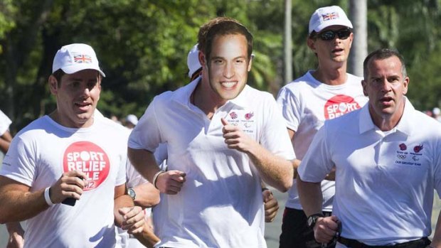 Britain's Prince Harry takes part in a fun run while wearing a mask of his brother Prince William in Rio De Janeiro.