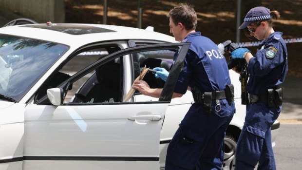 Forensic police remove evidence from the car on Saturday.