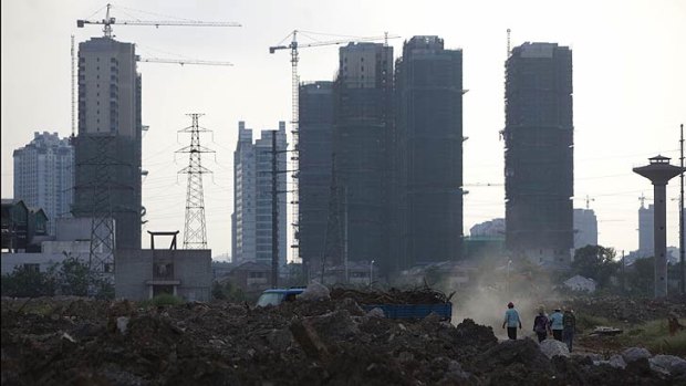 Workers walk at a demolished quarter at an abandoned steel plant in Wuxi, Jiangsu province.