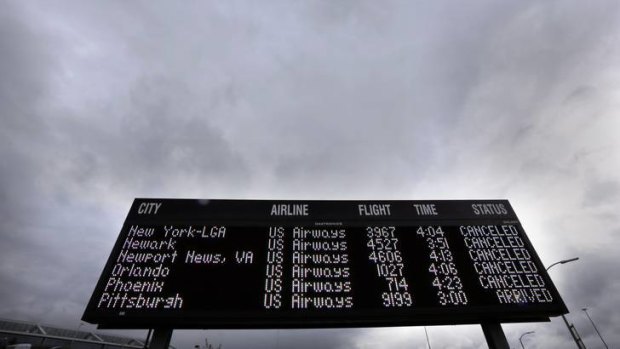 An outdoor sign lists cancelled flights at Philadelphia International Airport.