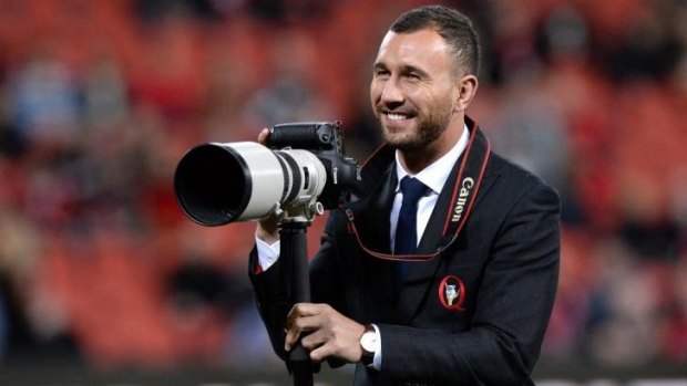 Paparazzi: Injured Reds five-eighth Quade Cooper grabs a camera to take a few pre-game snaps of his teammates.