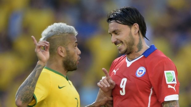 Chile's forward Mauricio Pinilla (R) argues on the field with Brazil's defender Dani Alves.
