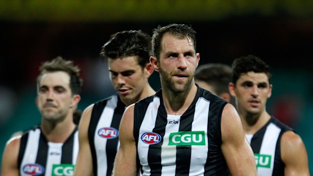 Outclassed: Dejected Magpies players trudge off the field.