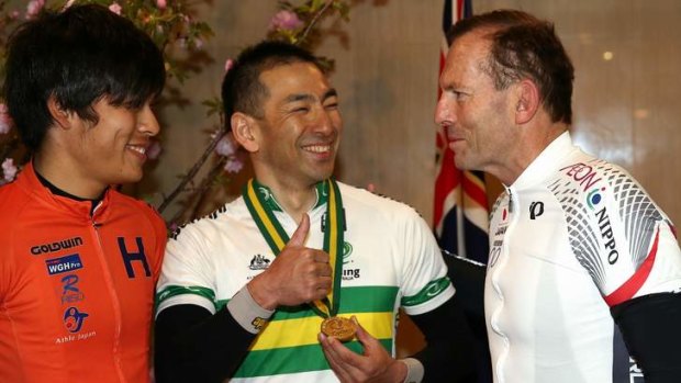 Cyclists Minori Shinmura and Kouji Yoshii speak with Mr Abbott after their ride in Tokyo on Sunday.