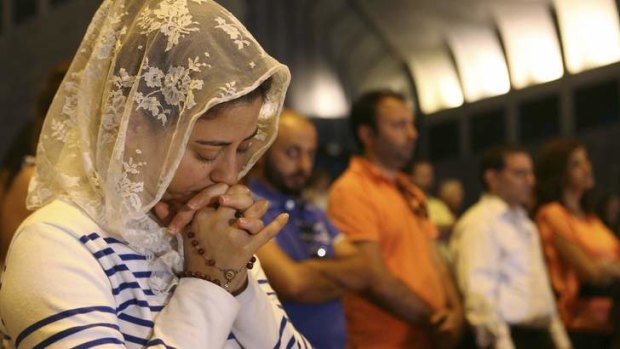 Desperate for peace: Lebanese and Syrian Christian Maronites pray in Harisa.