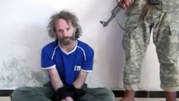 A video still shows US reporter Peter Theo Curtis being held hostage by an al-Qaeda linked group in Syria.