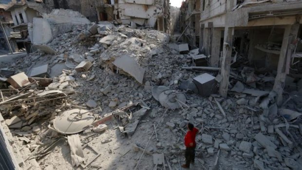 A Syrian man looks at the rubble of a five-storey apartment building destroyed in a barrel bomb attack in Aleppo.