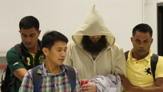 Philippine police escort Australian Islamic preacher Musa Cerantonio through Manila airport. 