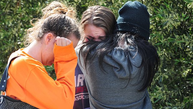 Young friends break down in tears at the crash scene, where three people died.