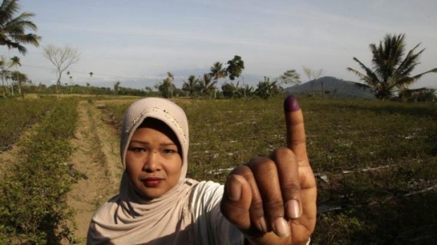 Inked in: A woman in Brambang Darussalam, East Java, after voting on Wednesday.