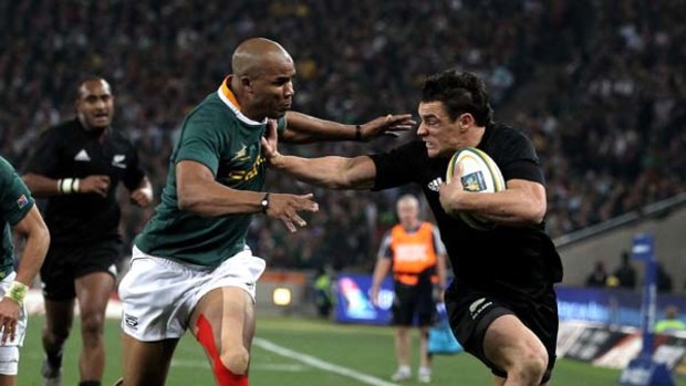 Dan Carter of the All Blacks holds off JP Pietersen in Soweto on Saturday night.