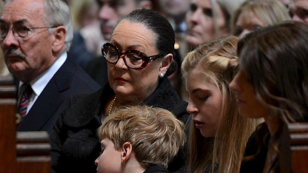 Jim Stynes' family, including son Tiernan, left, daughter Matisse and widow Sam listen to the service.
