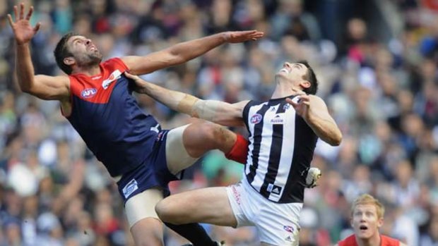 The big men fly as Melbourne's Mark Jamar and the Pies' Darren Jolly do battle at the MCG.