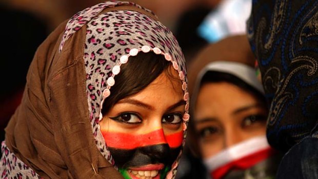A Libyan anti-government protester with her face painted in the colours of Libya's old national flag.
