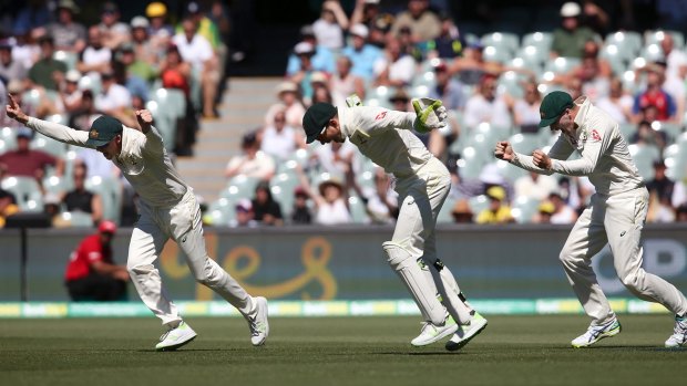 Australia's Steve Smith, left, Tim Paine and Peter Handscomb, right celebrate the fall of the last English wicket at the end of their Ashes cricket test match in Adelaide, Wednesday, Dec. 6, 2017. Australia won by 120 runs. (AP Photo/Rick Rycroft)