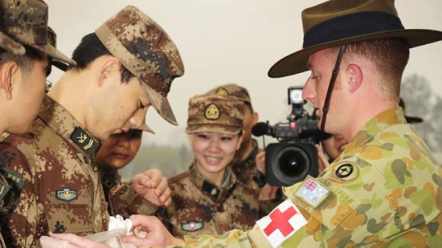 Leading Aircraftman Phil Beggs demonstrates his field-dressing technique to members of the People's Liberation Army during Exercise Co-operation Spirit in Sichuan Province, China.