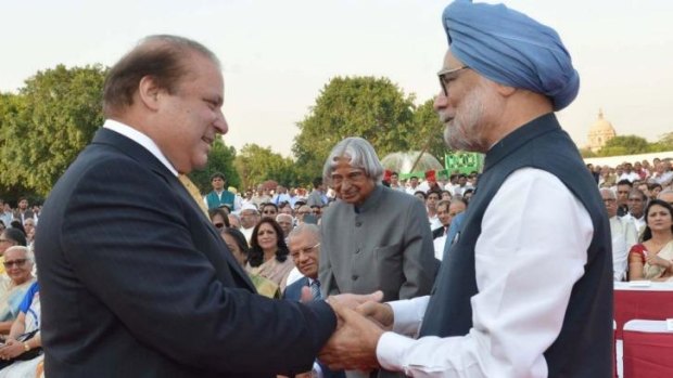 Pakistani PM Nawaz Sharif (left) shakes hands with outgoing Indian PM Manmohan Singh (right) as former Indian president APJ Abdul Kalam (centre, background) looks on during the swearing-in ceremony for Indian PM Narendra Modi.
