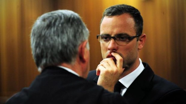Oscar Pistorius speaks to his lawyer Barry Roux during his murder trial.
