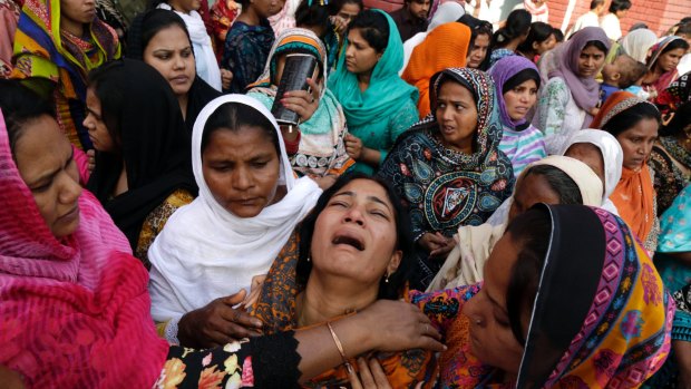 People try to comfort a Pakistani Christian mother during the funeral of her two daughters, killed in a suicide bombing by a Pakistan Taliban faction in Lahore in March.
