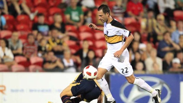 Now in sky blue . . . Andrew Durante of the Wellington Phoenix outwits a player for the Newcastle Jets, his former club, in November.
