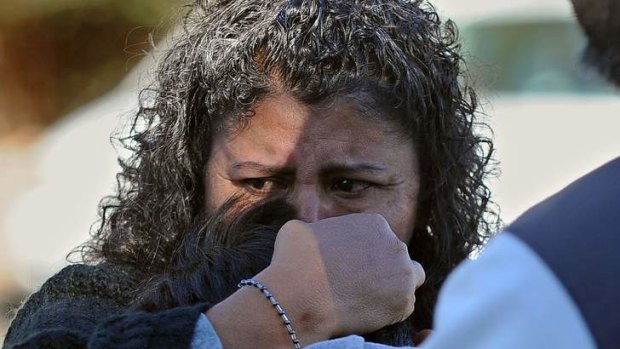 A woman holds her son after picking him up at following a school shooting in Sparks, Nevada.