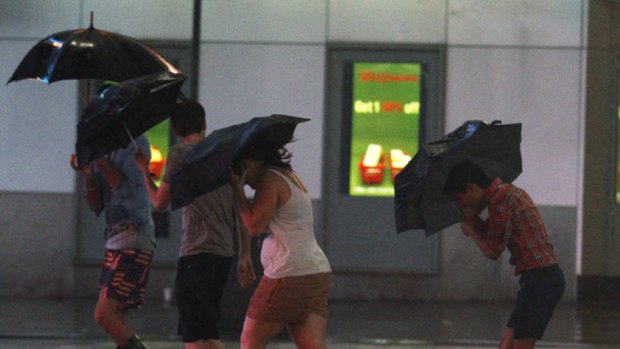Tourists walk through Times Square as Hurricane Irene arrives in New York.