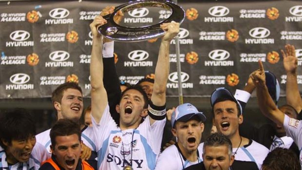 Standing the test of time . . . Sydney FC skipper and foundation squad member Terry McFlynn holds aloft the A-League championship trophy after last year's grand final victory.