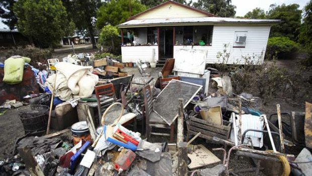 Ruined belognings are piled outside the Eather family's home in Condamine as the heart breaking clean-up begins.