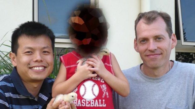 Peter Truong and Mark Newton (at right) with their adopted son known as Boy 1 (his face pixelated).