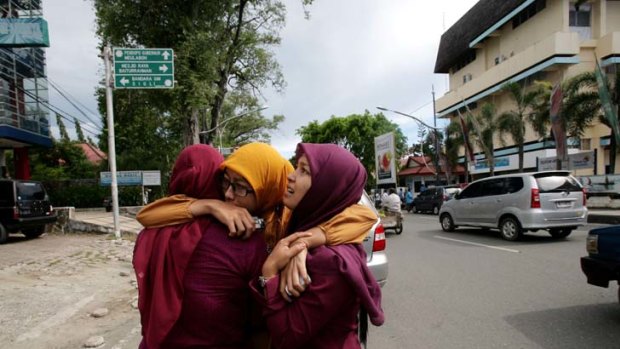 Panic ... Acehnese women hug each other and pray shortly after the earthquake struck.