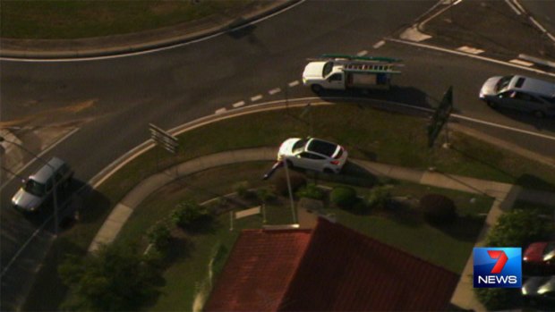 The white Hyundai mounts a footpath during the police chase south of Brisbane.