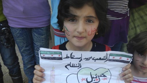 A girl in Kafranbel, near the town of Idlib. Her sign reads 'the people want the fall of the regime'.