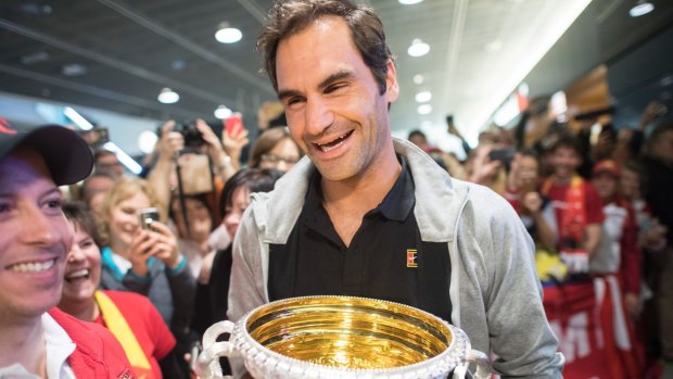 All smiles: Roger Federer lands in Zurich with the Australian Open trophy.