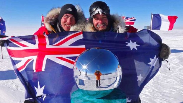 Justin Jones (left) and James Castrission plant the Australian flag at the South Pole at the half-way point of their 2220km unaided expedition from the edge of Antarctica to the Pole and back.