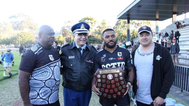 Acura Niuqila (with trophy) celebrates with Tribal Warriors CEO Shane Phillips, Pat Aboud and correctional officer Peter Shiraz after helping Redfern All Blacks win a grand final against Coogee Randwick.