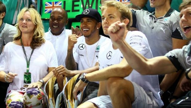 Lewis Hamilton celebrates winning the Singapore Grand Prix with his team including Nico Rosberg of Germany, his father Anthony Hamilton and his step-mother Linda Hamilton.
