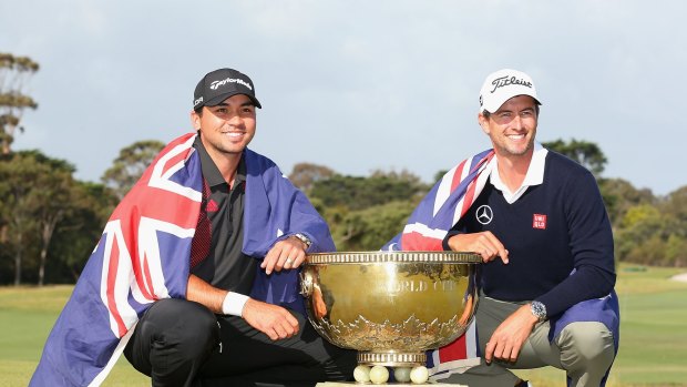 Team success: Australia's Jason Day and Adam Scott pose with the trophy after winning the teams event  of the World Cup of Golf in 2013.